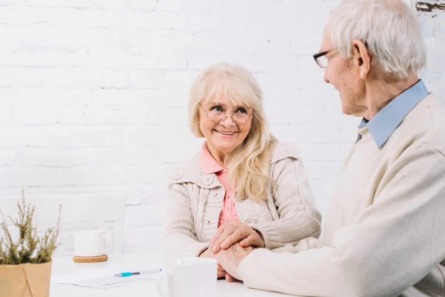 Older couple at a table talking through their Medicare paperwork